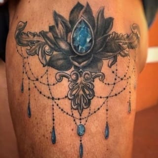 Tattoo: ornamental artwork with big blue stone in center